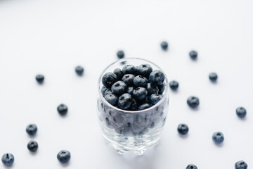 Beautiful ripe blueberries in a transparent glass glass on a white background. Healthy food, and vitamins.