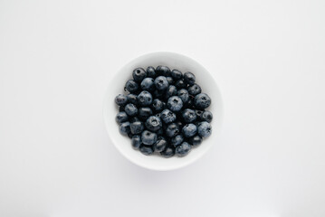 Beautiful ripe blueberries in a glass bowl on a white background. Healthy food, and vitamins.