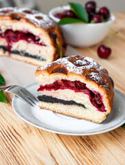 American pie on plate on rustic wooden board with full cake and sweet cherry berries on background. Easy recipe of cherry cake, vegan dessert gluten free. Homemade bakery with flaky crust.