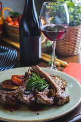 Fried ribs with a glass of red wine on a table in a restaurant close-up