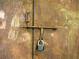 Closed padlock on a metal door.