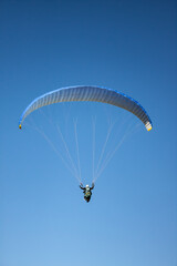 Paraglider flying in the mountain. The sea in the background in the photograph