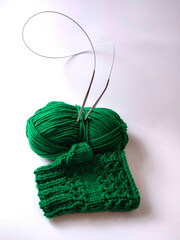 handmade green mitt and knitted threads
