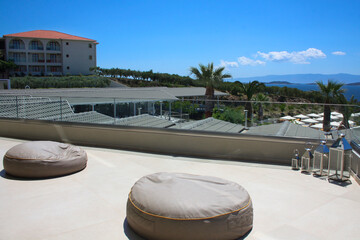Recreation area on the roof overlooking the sea and palm trees. Comfortable large bag chairs. Mountains are in the distance. 
