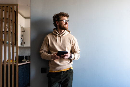 Man with digital tablet day dreaming at home