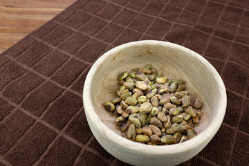 No Shell Pistachios with Sea Salt Close-up in a Round Wood Bowl