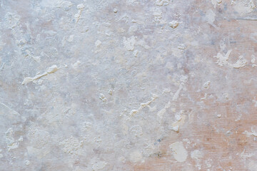 The working platform of the painting table is made of plywood. The surface has a wooden texture and is stained with paint and putty of various shapes. Background. Construction.