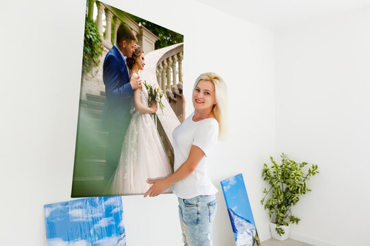 woman holding photo canvas on the background of a interior