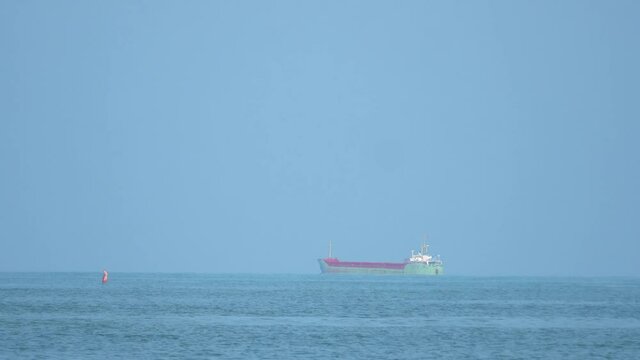 Container cargo ship sailing in calm water at sea horizon
