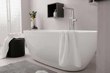 Stylish bathroom interior with modern white tub