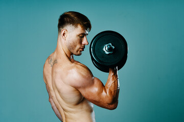 Fototapeta na wymiar bodybuilder with a muscular body with dumbbells in his hands fitness