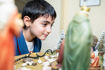 six-year-old boy looks at the Christmas nativity scene in xmas morning