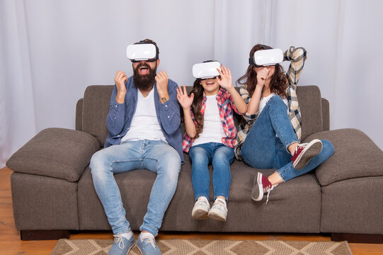 glad family wear vr glasses sitting on sofa at home, future technology