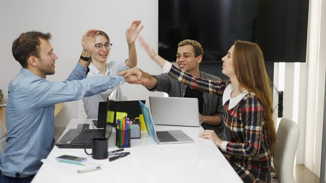 Positive team at office gathering hands together, teamwork concept