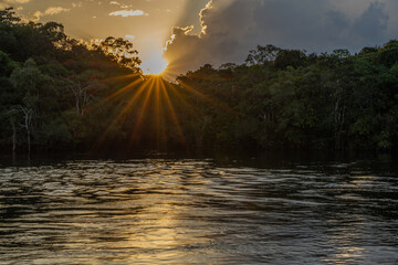 Reflection of a sunset by a lagoon inside the Amazon Rainforest Basin. The Amazon river basin...