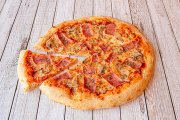 Family-size pizza with cooked ham, mozzarella cheese, oregano and sliced mushrooms