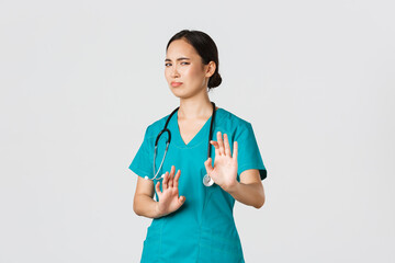 Covid-19, healthcare workers, pandemic concept. Reluctant funny asian nurse, doctor avoiding...