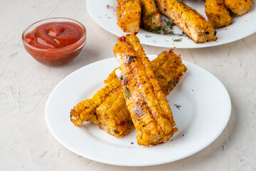 Grilled corn with barbecue spices. Imitation of ribs. Corn ribs.