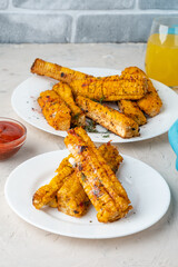 Barbecued corn patches with paprika and butter. Vegetarian dish. Corn ribs.