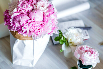 Bouquet of peonies in kraft paper bag