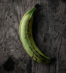 Green plantain banana on wooden background in black and white