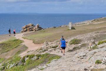 Fototapeta premium People,walking along the wild coast at the Quiberion peninsula in Brittany France