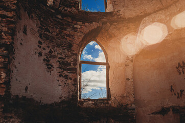 View of clouds through twindow of  ruined fortress. Sun glare.