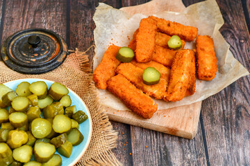 Close up of   Crispy breaded  deep fried fish fingers with breadcrumbs served  with remoulade sauce and  lemon Cod Fish Nuggets on rustic wood table background
