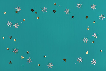 Christmas holiday turquoise background with golden and silver snowflakes and confetti