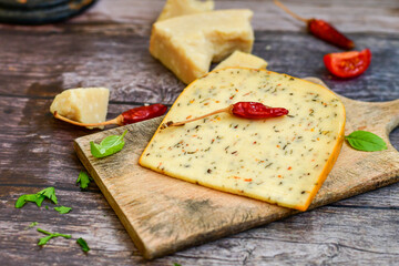  Set of different kinds ot delicious   Italian hard  cheeses,  cheese knives  and walnuts on wooden cheese board.Parmesan. Top view.
