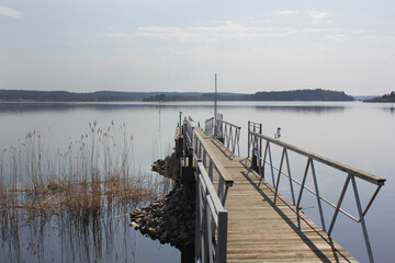 a wooden pier on a quiet serene lake. Peaceful rural landscape