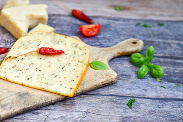 Mediterranean style  hard cheese with  tomatoes , olives and basil on wooden background