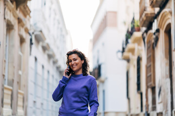 Cheerful man talking on smartphone on street