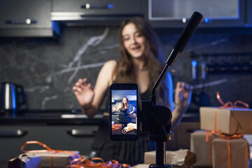 Fototapeta na wymiar influencer woman filming video showing her gifts, influencer woman dances while broadcasting video