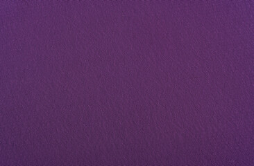 The background is made of purple material. Fabric for sewing clothes in a dark shade. Texture