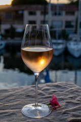 Tasting of local rose wine in summer with sail boats haven of Port Grimaud on background, Provence, France