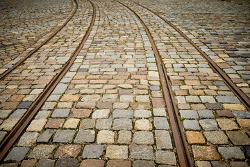 The antique tram railway track on stone pavement - perspective view