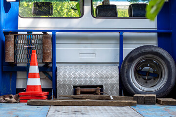 The platform from the back of an evacuator car with the red road cones and wheel.