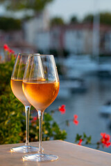 Tasting of local rose wine in summer with sail boats haven of Port Grimaud on background, Provence, France