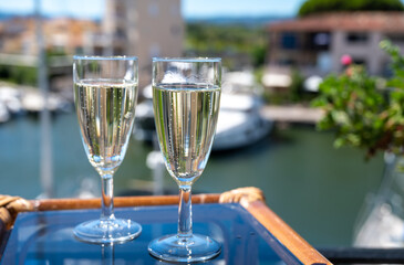 Summer party with sparkling champagne wine and sail boats haven of Port Grimaud on background, Provence, France