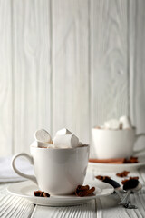 Mug with hot chocolate and marshmallows on wooden table
