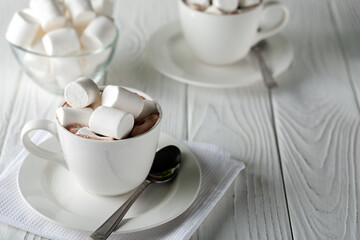 Fototapeta na wymiar Mug with hot chocolate and marshmallows on wooden table