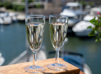 Summer party with sparkling champagne wine and sail boats haven of Port Grimaud on background, Provence, France