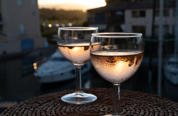 Drinking of local rose wine at sunset with sail boats haven of Port Grimaud on background, Provence, France