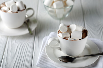 Mug with hot chocolate and marshmallows on wooden table