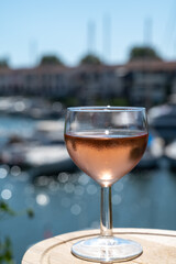 Tasting of local rose wine in summer with sail boats haven of Port Grimaud on background, Provence, France