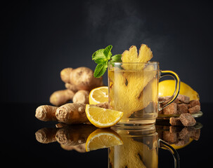 Ginger tea with ingredients on a black background.