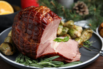Delicious ham served with brussels sprouts and rosemary on table, closeup. Christmas dinner