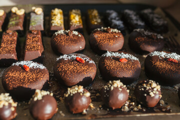 closeup various handmade vegan and sweet chocolate cakes on a kitchen tray