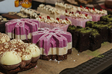 closeup various handmade vegan and sweet chocolate cakes on a kitchen tray